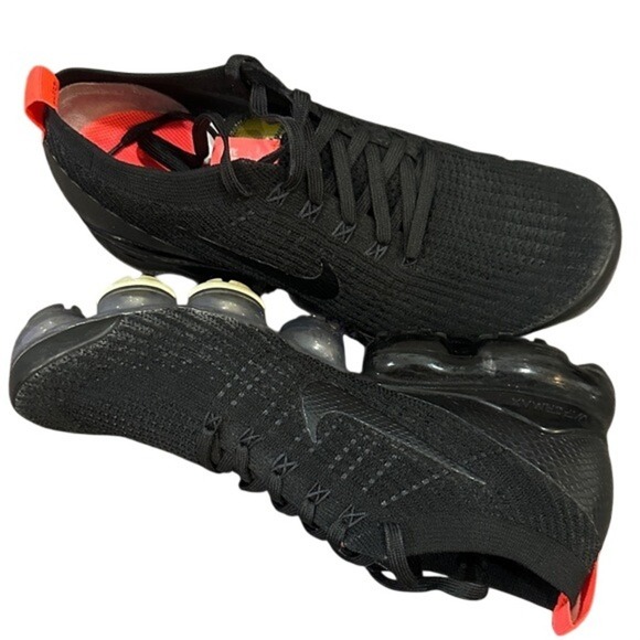 black Nike Air VaporMax Flyknit 3 sneakers with bright crimson/orange accents